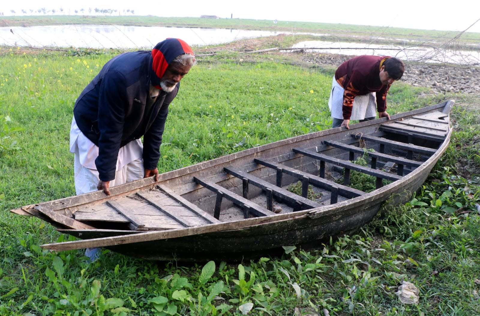 পদ্মা নদীর পানি কমে যাওয়ায় চরাঞ্চলের বালুতে আটকে গেছে নৌকা। কৃষিকাজ ও যাতায়াতের প্রয়োজনে কৃষকরা নৌকা বের করার চেষ্টা চালাচ্ছেন। ছবি: শরিফুল ইসলাম তোতা।